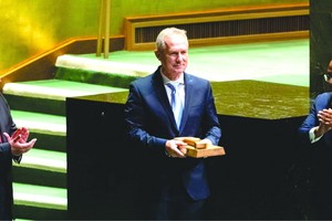 聯大第七十七屆會議當選主席克勒希（中）接過議事槌，古特雷斯與沙希德為其鼓掌。