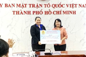 市越南祖國陣線委員會主席陳金燕接受捐款。