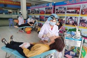 醫護人員在“為勞動者健康”盛會上給越南寶元有限責任公司工人們檢查體康。（圖：H. Đào）