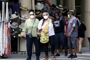 人們在美國路易斯安那州新奧爾良市戴著口罩出行。（圖：新華社）