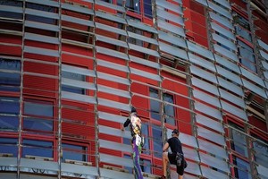 阿蘭‧羅貝爾(左)和兒子在“榮耀塔”上攀爬。