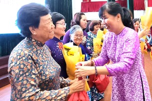 第五郡婦聯會主席陳氏雪幸向華人婦女 李金梅女士贈送鮮花。