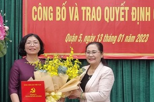 市委副书记、市人民议会主席阮氏丽(右)向黄玉女芳红同志颁发第五郡郡委书记《决定》。