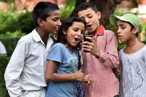 在印度德里的圣哥伦巴学校，孩子们在使用手机。