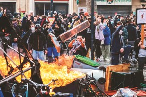 法国民众23日再次集结走上街头、抗议总统马克宏强行通过退休制度改革法案，包括巴黎和其他多个城市，皆传出示威群众与警方发生冲突。图／法新社