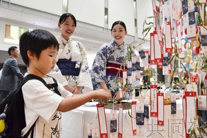 一名男孩挂上心愿纸笺。