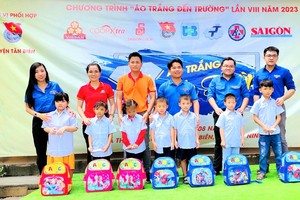 代表团向学生赠送助学金、校服与文具。