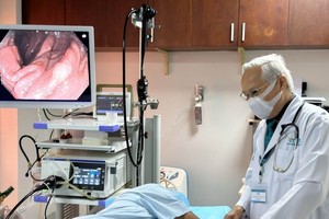 阮春蓝医生正在为病人诊治。