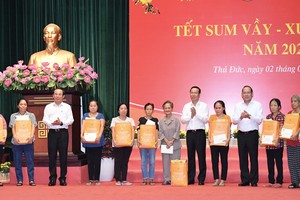 国家主席武文赏、市委书记阮文年向贫困工人、劳动者、贫困户赠送礼物。