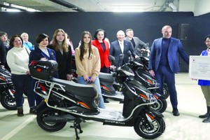 出席日本电动踏板车交付仪式的人们。