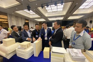 万成乳胶床垫公司副总经理杨庆云（右三）向参观者介绍产品。