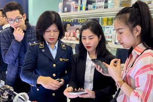 市场管理干部指引消费者辨识真假商品。