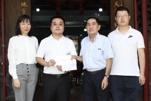 中国驻本市总领事馆代表团向霞漳会馆理事长沈金麟移交捐款。