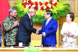 政府总理范明政与东盟商务咨询理事会老挝主席苏瓦纳丰交谈。