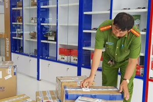 Công an tiến hành niêm phong hàng hóa tại zShop Cần Thơ. Ảnh: LÊ PHƯƠNG