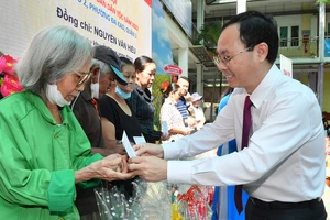 Phó Bí thư Thành ủy TPHCM Nguyễn Văn Hiếu tặng quà cho hộ nghèo tại Ngày hội Đại đoàn kết toàn dân tộc, khu phố 2, phường Đa Kao, quận 1. Ảnh: VIỆT DŨNG