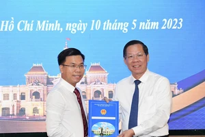 Chủ tịch UBND TPHCM Phan Văn Mãi trao quyết định bổ nhiệm cho ông Phạm Trung Kiên. Ảnh: VIỆT DŨNG