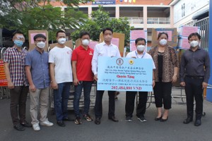 康洋工業園區董事長徐豐培（左五）向第十一郡醫院副院長黎德雅（右三）移交醫療設備和防護物資。