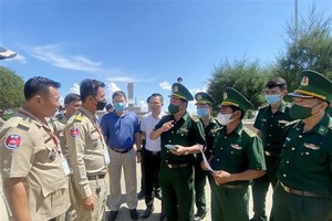 靖邊國際口岸邊防哨所幹部與柬埔寨職能力量就接收26名越南公民的手續進行交談。 