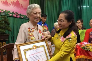 市委副书记、市人民议会主席阮氏丽向叶秀英大娘颁发70年党龄纪念章。