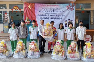 光正学校董事长张宏辉向贫困学生赠送新年礼物。