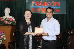 王欣然领事向本报编委文忠孝移交善款。