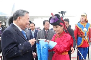 在成吉思汗机场，蒙古国姑娘按照传统习俗向党中央总书记、国家主席苏林献上奶片。图自越通社
