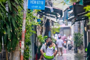 街上水淹，家长要背孩子上学。（图源：tuoitre）