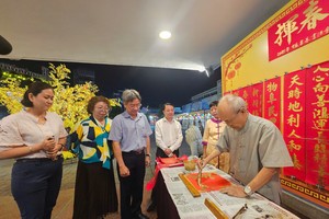 第五郡人委会副主席阮武春奇参观挥春贺岁展位。