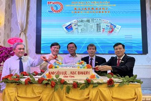 各位领导、代表登台切蛋糕庆祝华文《西贡解放日报》创刊五十周年。