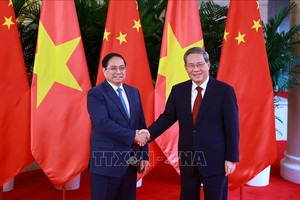 越南政府总理范明政和中国国务院总理李强。图自越通社