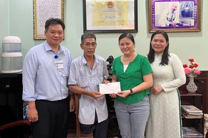 温陵会馆常值副会长吳丽株（右二）把半年生活额交给荣军阮文秋。