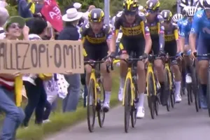 Người phụ nữ cầm bảng “Allez Opi-Omi” lấn đường đua