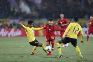 Quang Hải giữa vòng vây của hậu vệ Malaysia. Ảnh: DŨNG PHƯƠNG