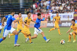 Mạc Hồng Quân trước vòng vây của các hậu vệ SLNA. Ảnh: MINH HOÀNG