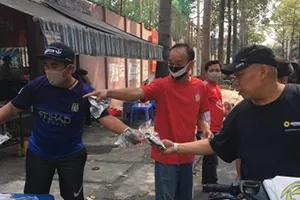Hội CĐV CLB TPHCM phát khẩu trang cho người đi đường trên đường Đào Duy Từ. Ảnh: Anh Trần