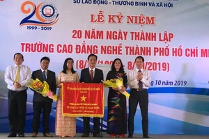 Ông Lê Minh Tấn, Giám đốc Sở LĐTB-XH TPHCM ( ngoài cùng bên trái) đại diện UBND TPHCM trao bức trướng của UBND TPHCM cho Ban Giám hiệu nhà trường