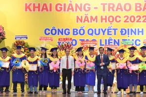 Ông Phạm Tất Thắng, Phó trưởng ban Thường trực Ban Dân vận Trung ương (áo trắng) và TS Lê Lâm, Hiệu trưởng Trường Cao đẳng Đại Việt Sài Gòn trao giấy khen và hoa cho đại diện 177 sinh viên học tập xuất sắc, học giỏi tốt nghiệp ra trường