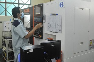 A worker operates CNC machine in Duy Tan Plastic Company. (Photo: SGGP)