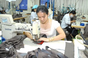 Workers make suit jackets for export. (Photo: SGGP)