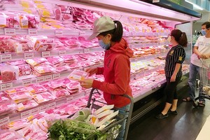 Consumers buy pork at a supermarket. (Photo: SGGP)