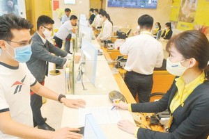 Customers do transactions at a bank in Ho Chi Minh City. (Photo: SGGP)