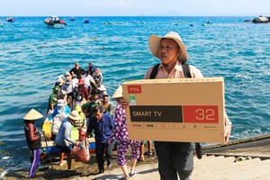 A resident on Nhon Chau Island buys a television to use after the island connects to the national power grid. (Photo: SGGP)