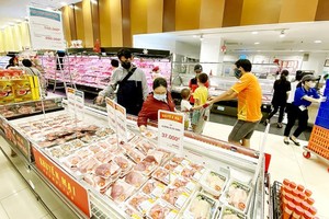 Consumers buy pork at a supermarket. (Photo: SGGP)