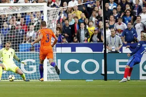 Antoine Griezmann (phải, Pháp) tung cú sút hạ thủ môn Jasper Cillessen của Hà Lan.