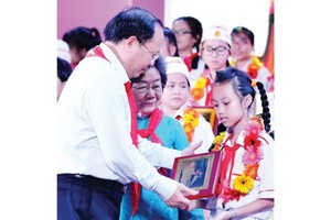 Standing Deputy Secretary of the Ho Chi Minh city Party Committee Tat Thanh Cang offered certificates of merit to outstanding children. (Photo: Sggp)