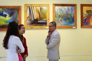 Painter Vo Trinh Bien ( R) at the exhibition (Photo: Sggp)