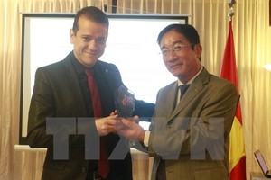 Vietnamese Ambassador to Brazil presents the National External Information Service Awards 2016 to William Gsiant, a presenter of TV Supren (Photo: VNA) 