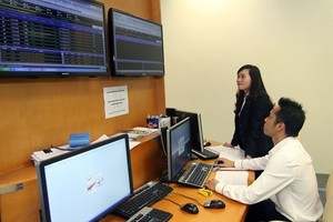 Specialists monitor a bidding session on the Hanoi Stock Exchange. (Photo: VNA)