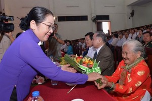 HCMC deputy Party Secretary Vo Thi Dung offers flowers to a Vietnamese heroic mother at the ceremony. (Photo: Sggp)